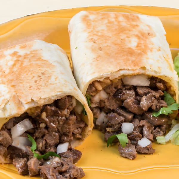 Two El Dorado Mexican Restaurant burritos, cut in half, revealing beef, onions, and cilantro on a yellow plate.